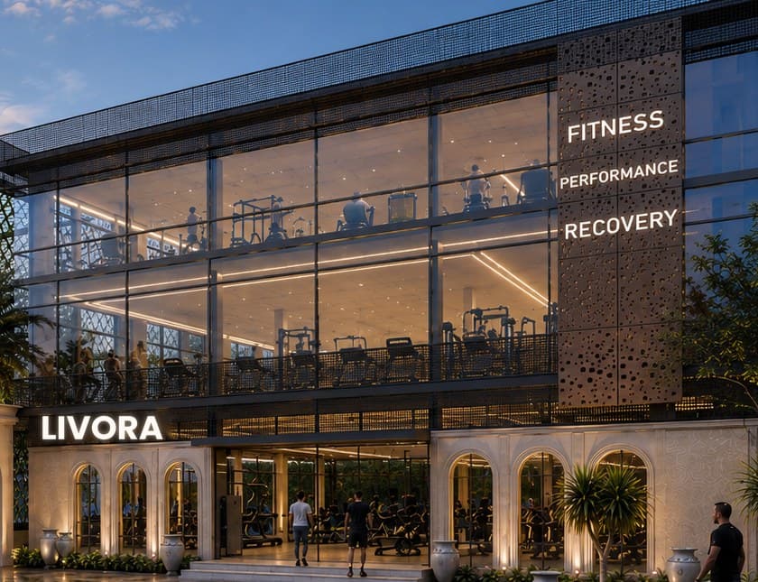 The glazed training hall: two floors of equipment behind full-height glass, beside a perforated bronze screen.